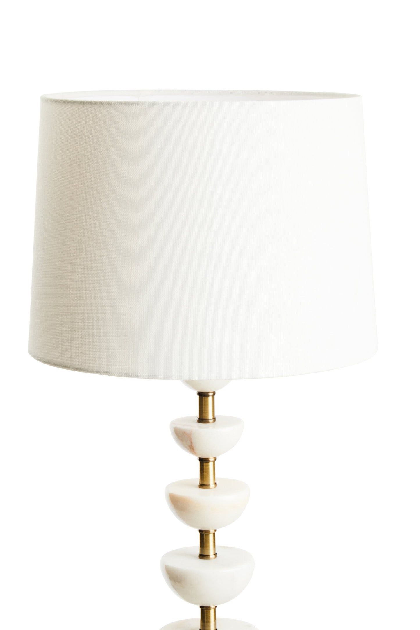 Table lamp with a white shade and decorative base on a white background