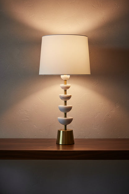 Table lamp with white shade and gold base on a white background