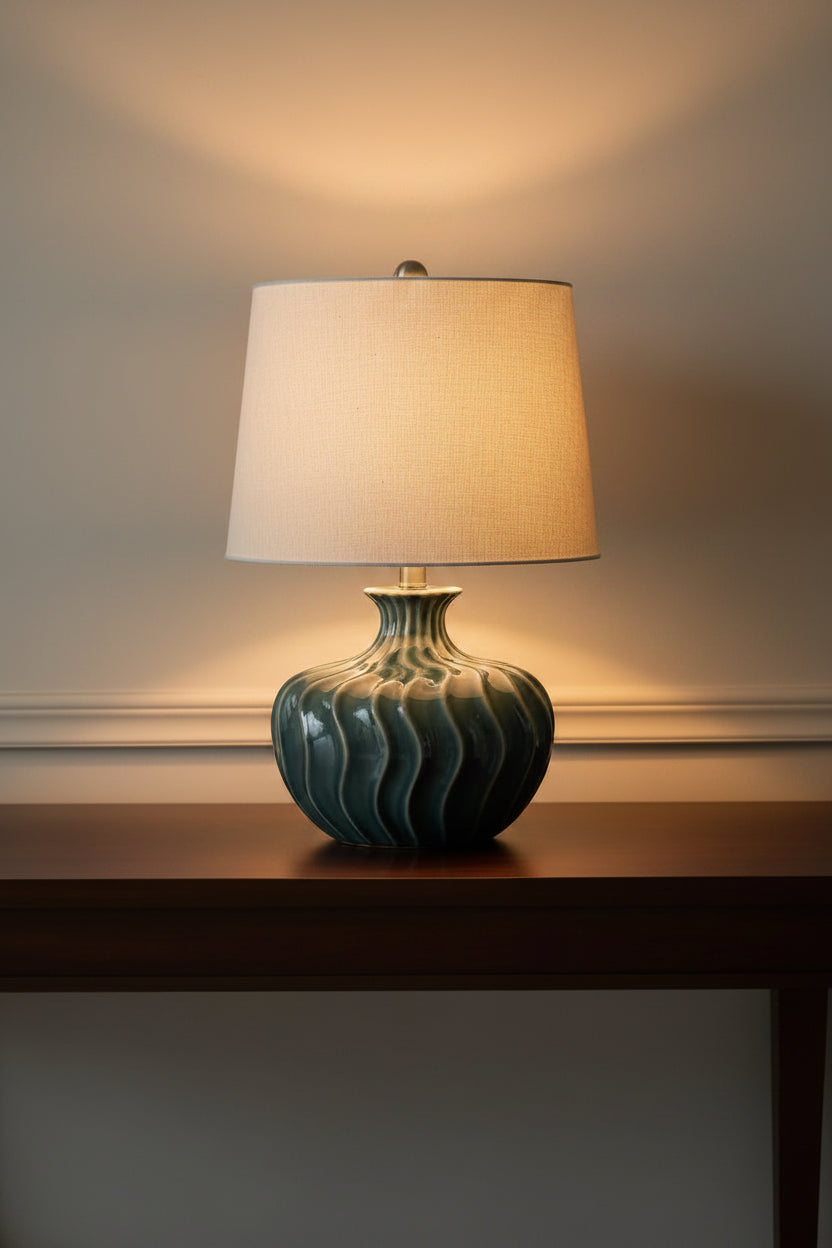 Table lamp with a textured ceramic base and beige lampshade on a white background