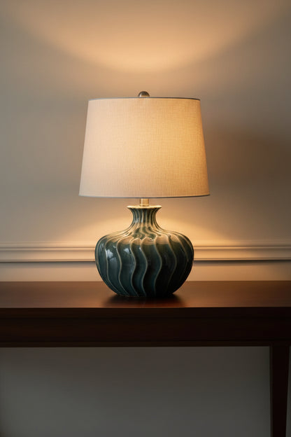 Table lamp with a textured ceramic base and beige lampshade on a white background