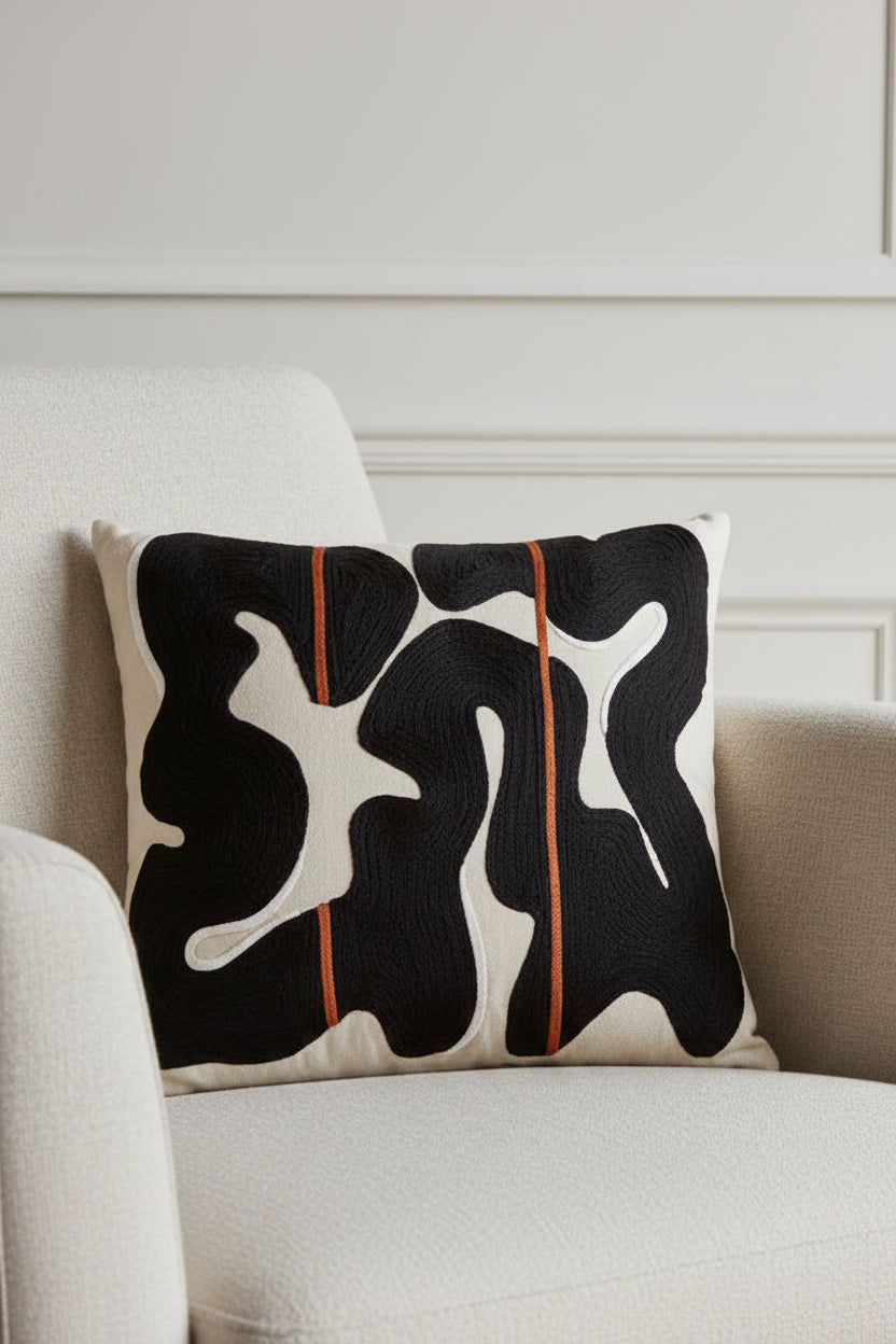Decorative pillow with abstract black and white pattern on a beige background