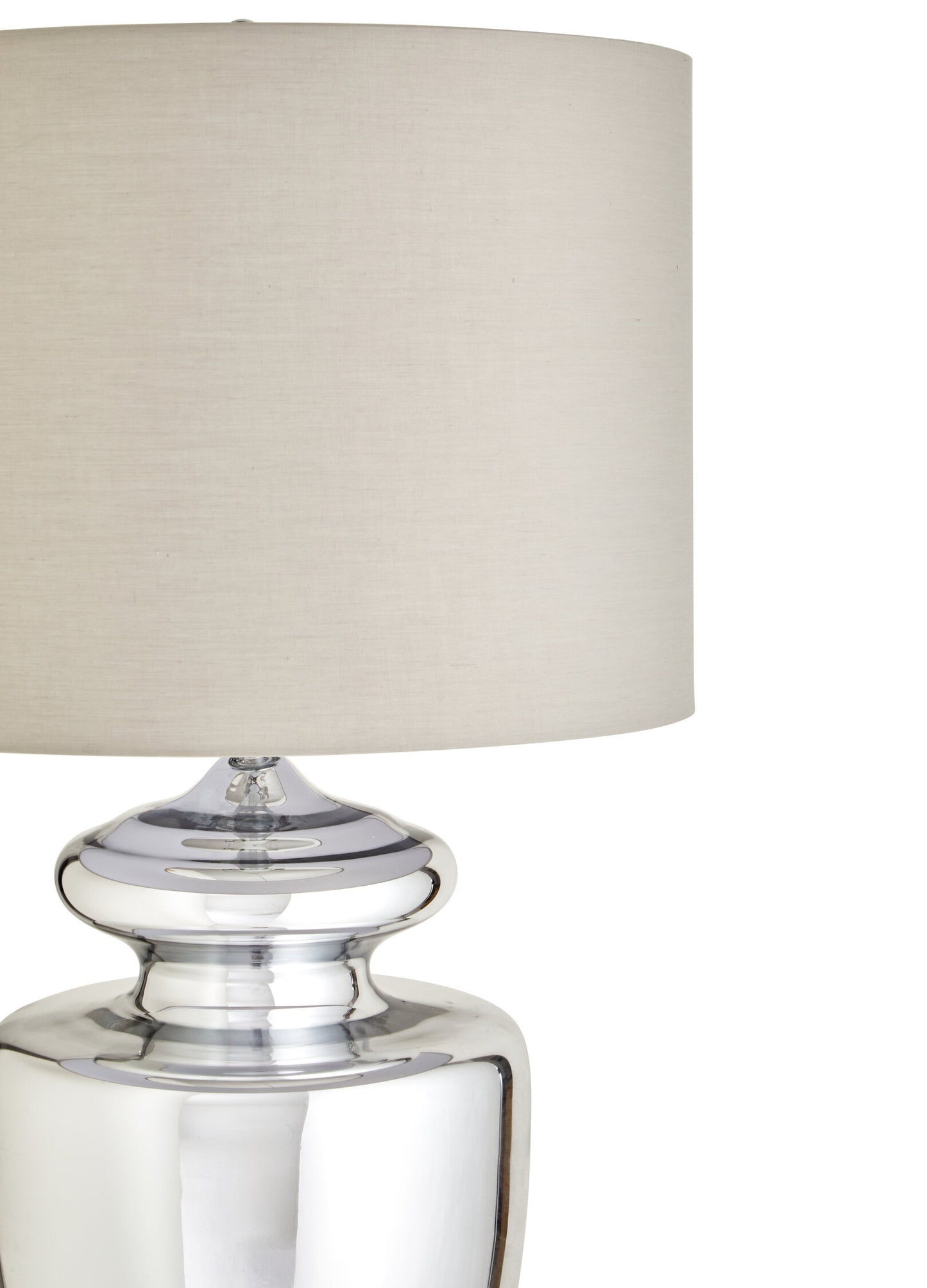 Table lamp with a clear glass base and beige fabric shade on a white background
