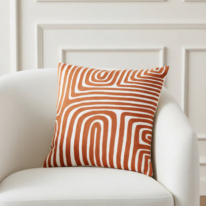Decorative pillow with brown and white wavy pattern on a white background