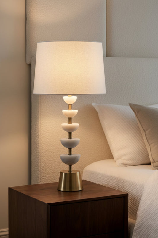 Decorative lamp on a nightstand next to a bed with pillows