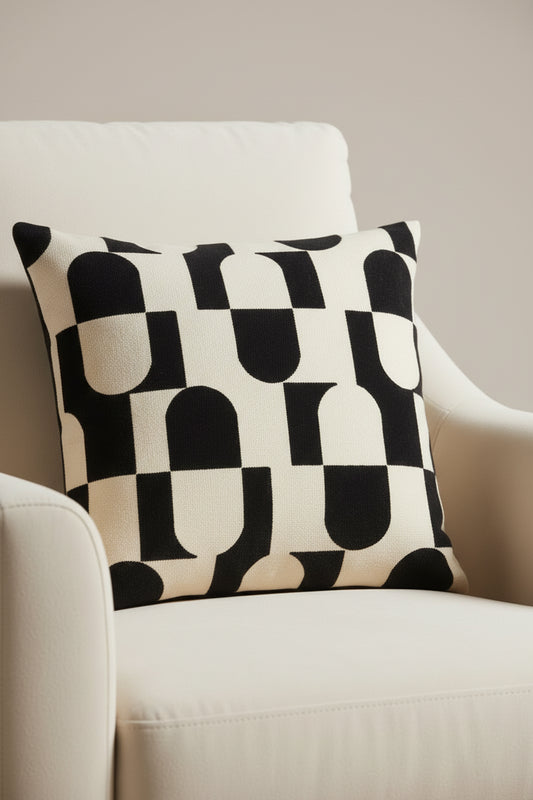 Decorative pillow with black and white abstract pattern on a beige background