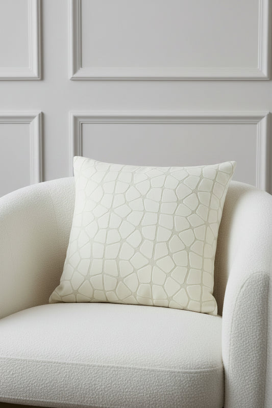 A square throw pillow featuring a textured, raised geometric pattern resembling a stone or reptile skin motif in a light beige and off-white color palette, shown against a plain white background.