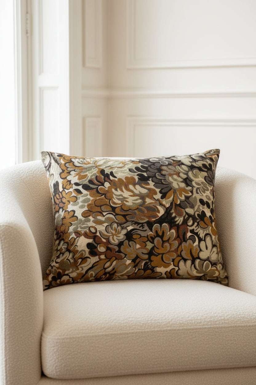 Decorative pillow with floral pattern in brown, beige, and black on a white background