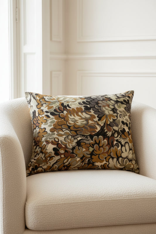 Decorative pillow with floral pattern in brown, beige, and black on a white background