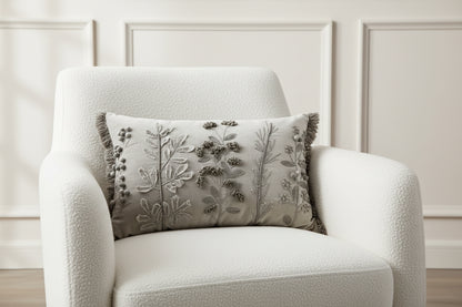 Decorative pillow with floral embroidery and tassels on a white background