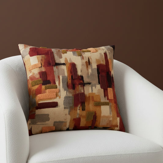 Decorative pillow with abstract pattern in earthy tones on a white background