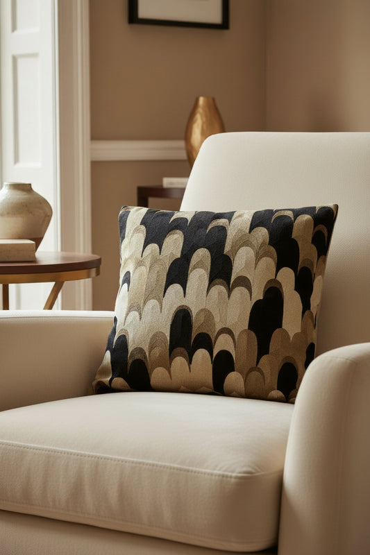 Decorative pillow with a black, brown, and beige abstract pattern on a white background