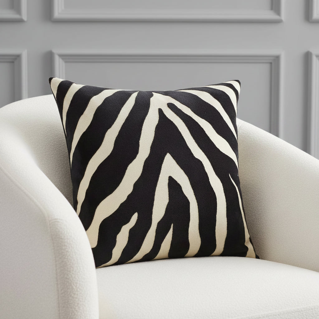 Zebra patterned pillow with black and beige stripes on a white background